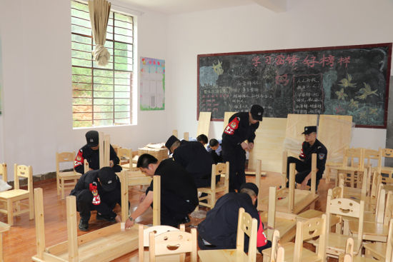 图为郎恒边境派出所民警和辅警在为安良小学安装课桌椅