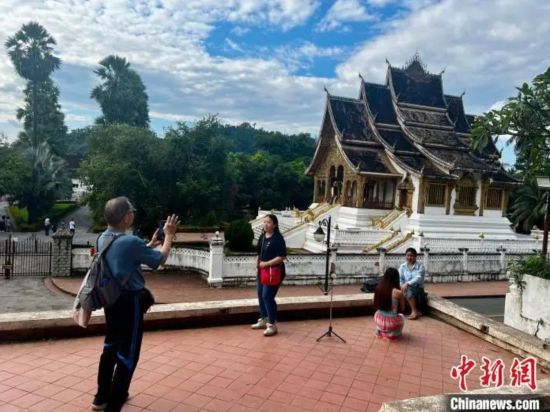 图为游客在老挝琅勃拉邦街头拍照打卡。张树娇 摄 图为游客在老挝琅勃拉邦街头拍照打卡。张树娇 摄